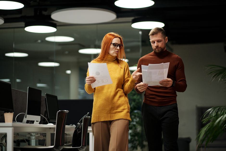 A person with a concerned expression sits in a modern office, carefully reviewing a contract, highlighting the legal and financial weight of a fiduciary's duties.